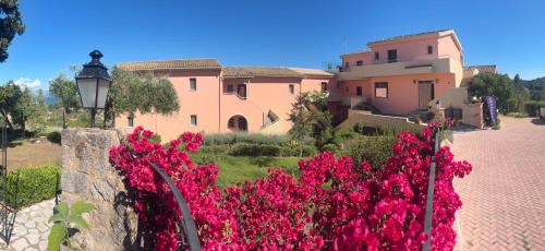 a house with pink flowers in front of it at Penelope Apartment Hotel in Dassia