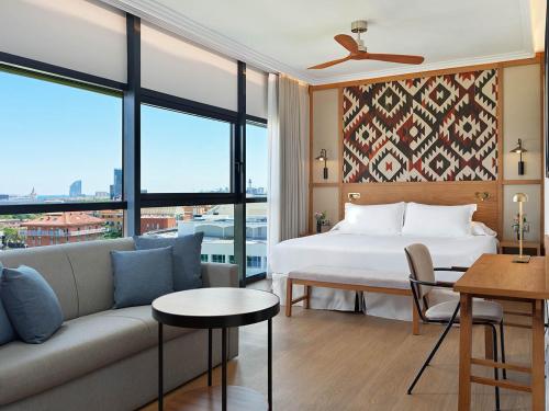 a hotel room with a bed and a couch at H10 Marina Barcelona in Barcelona
