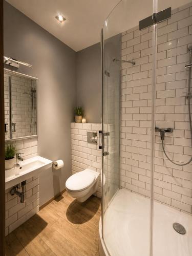 a bathroom with a shower and a toilet and a sink at Pensjonat Kocius in Rewal