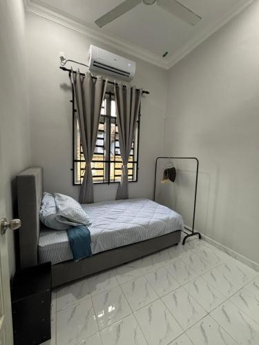 a bedroom with a bed and a window with a fan at D Teratak Homestay in Marang