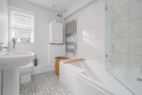 a white bathroom with a tub and a sink at Stoops Hall - 2 bed first floor apartment in Garstang