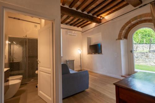 a living room with a blue couch and a bathroom at Private Villa San Luigi in Sarteano