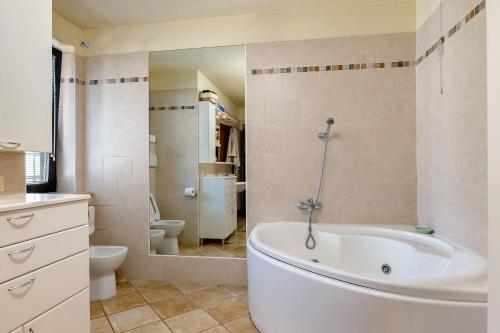 a bathroom with a white tub and a toilet at La Casa di Gio - 2 Camere Singole in Campanella
