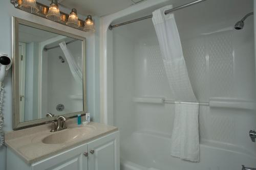 a bathroom with a sink and a shower with a mirror at Grande Shores Ocean Resorts Condominiums in Myrtle Beach