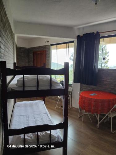 a room with two bunk beds and a table at Studio na Serra I in Itatiaia