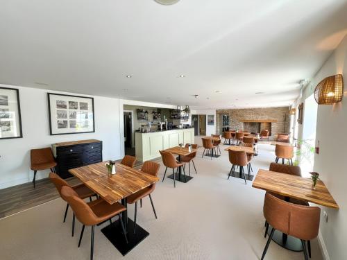 a dining room with wooden tables and chairs at The Llawnroc Hotel in Gorran Haven