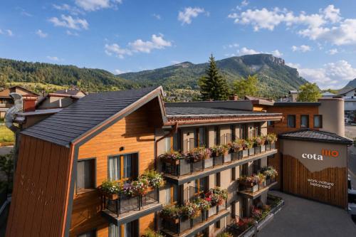 an apartment building with flower boxes on the balconies at Hotel COTA1110 in Beli Iskar