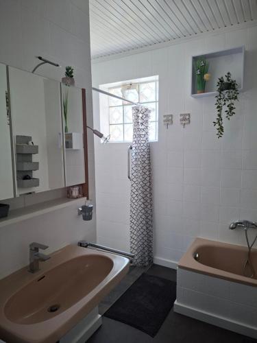 a bathroom with a tub and a sink and a shower at Ferienhaus Savannah in Schützen am Gebirge