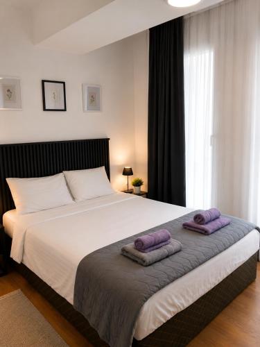 a bedroom with a large bed with two towels on it at SOLU Luxury Apartments with Free Parking ,Fast Wi -Fi, New Building in Skopje