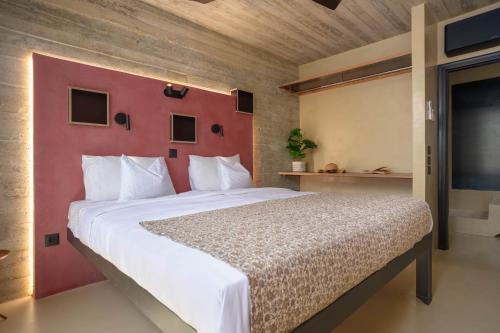 a bedroom with a large bed with a red wall at Turtle Home in Skala