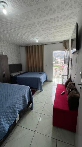 a hotel room with two beds and a couch at Kitnet aconchegante in Ouro Preto