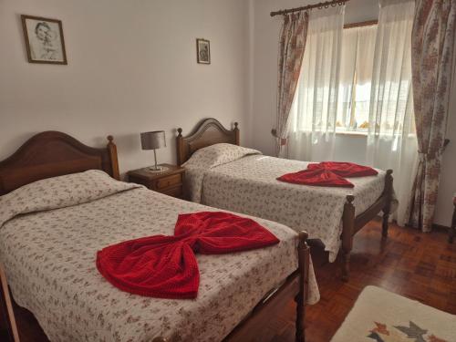 a bedroom with two beds with red bows on them at Vivenda Atlantico in Vila Praia de Âncora