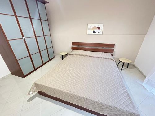 una camera da letto con un letto e due sgabelli di Regina34 a Torre a Mare