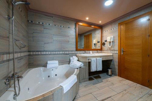 a large bathroom with a tub and a sink at Silken Antequera Hills in Antequera