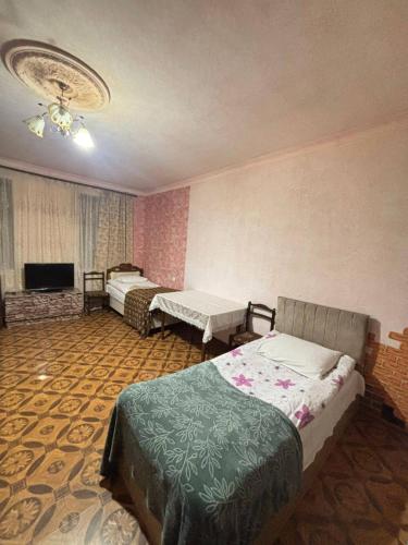 a bedroom with two beds and a flat screen tv at Matevosyans Guest House in Goris
