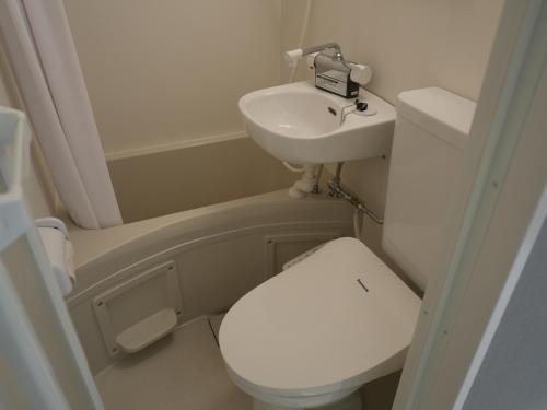a small bathroom with a toilet and a sink at attomi hostel 2 in Sapporo