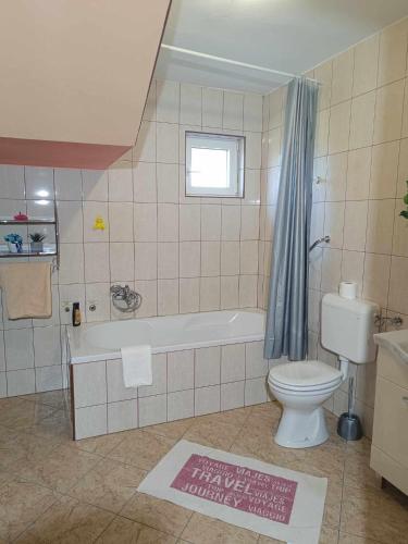 a bathroom with a tub and a toilet and a sink at Apartmani Tea i Toni in Gradište