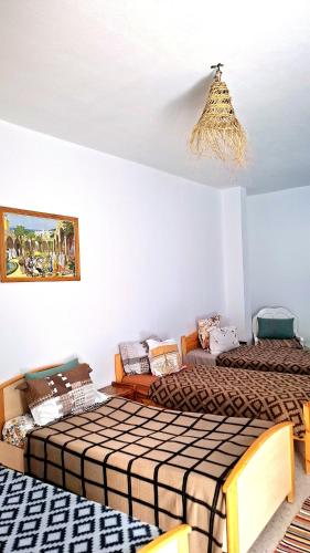a bedroom with two beds and a chandelier at Dar Aziz VIP in Sousse