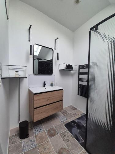 a bathroom with a sink and a mirror and a shower at M28 - Maison de campagne avec climatisation in Barby