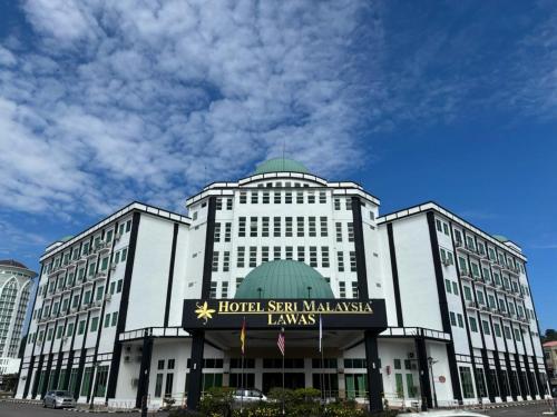 a large white building with a sign on it at Hotel Seri Malaysia Lawas in Lawas