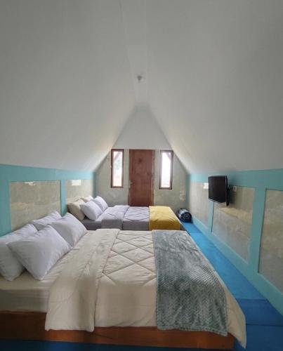 a large bedroom with two beds in a room at Sabda Desa Cabin in Cinyiruan