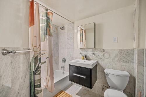 a bathroom with a toilet and a sink and a shower at Chic One Bedroom Retreat in Downtown Manhattan in New York
