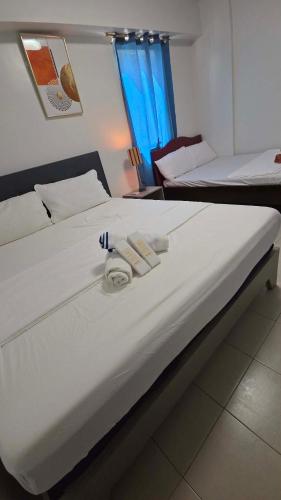 a large bed with two towels on top of it at Plumera Mactan Square in Mactan Island
