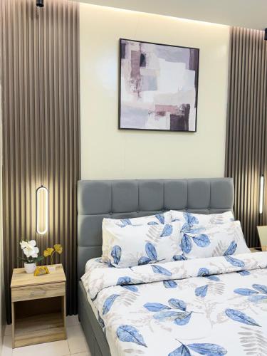 a bedroom with a bed with blue and white sheets at Eusel's Place Butuan in Butuan