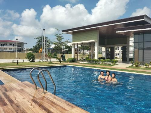 two people are swimming in a swimming pool at Plumera Mactan Square in Mactan Island