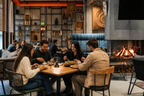 a group of people sitting around a table in a restaurant at Hotel COTA1110 in Beli Iskar