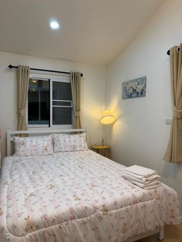a bedroom with a bed and a window at วันรีสอร์ท in Ratchaburi