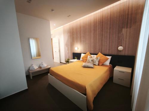 a bedroom with a bed with orange sheets and pillows at Le Due Muse b&b in Pagani