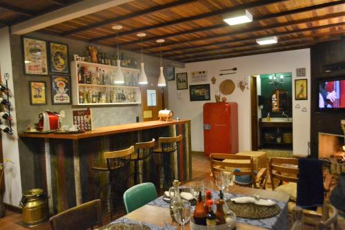 een restaurant met een bar met tafels en stoelen bij Pousada Encanto da Bocaina - Serra da Bocaina in São José do Barreiro