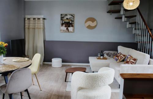 a living room with a couch and a table and chairs at Maison de charme in Bourgueil