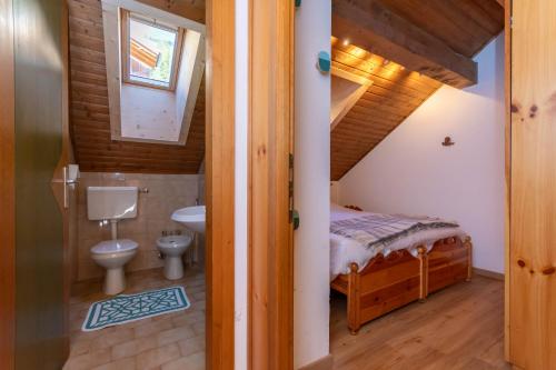 ein Badezimmer mit Bett und Toilette in einem Zimmer in der Unterkunft Ciasa pe de Bosc in Mazzin