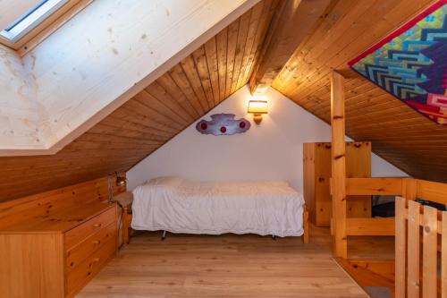 ein Schlafzimmer mit einem Bett auf dem Dachboden in der Unterkunft Ciasa pe de Bosc in Mazzin