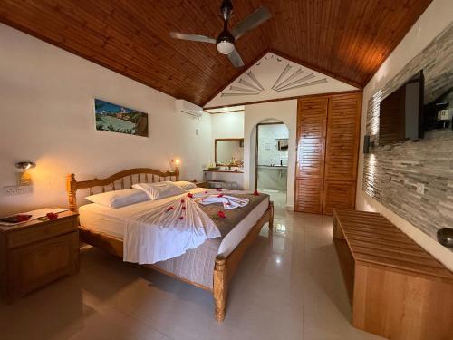 a bedroom with a large bed and a bathroom at Beach Villa Guesthouse in Grand Anse