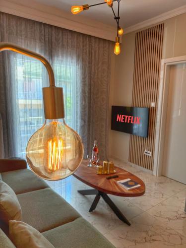 a living room with a large light hanging over a table at Psimithefto Luxury Apartments in Thessaloniki