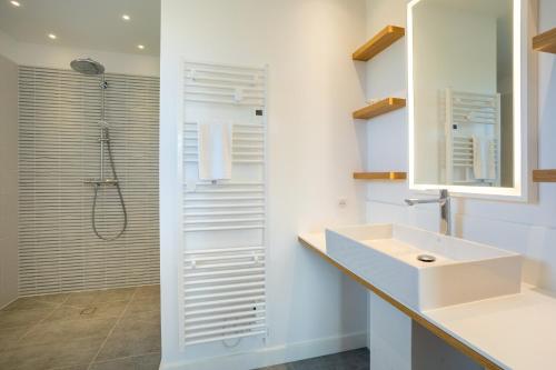a white bathroom with a shower and a sink at Aux flots de la Torche, 3ch in Penmarch