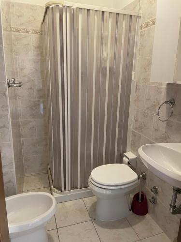 a bathroom with a shower and a toilet and a sink at Hotel del Corso in Sestola