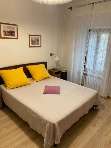 a bedroom with a large bed with yellow and purple pillows at Hotel del Corso in Sestola