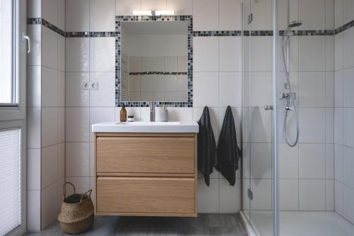 a bathroom with a sink and a shower at Design-FeWo Fleesensee, Wallbox, Sauna, Terrasse in Unter Göhren