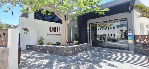a building with a tree in front of a door at 001 HIGOS BEACH BOUTIQUE Singular Hotel Residence in Costa Calma