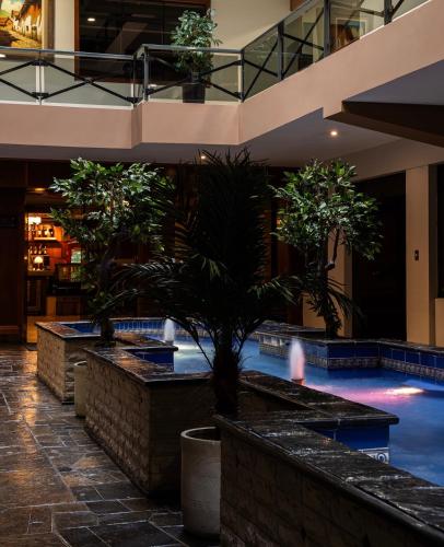 a swimming pool in a building with two potted trees at Gran Hotel Continental in Cajamarca