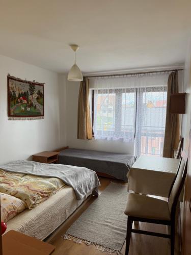 a bedroom with two beds and a window at Atticapartament in Kluszkowce