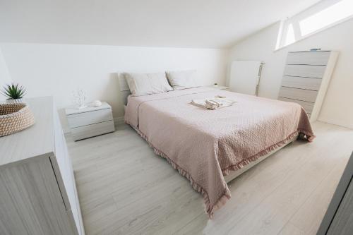 a white bedroom with a bed with a pink blanket at Casa Anastasia Beach Loft in Montesilvano
