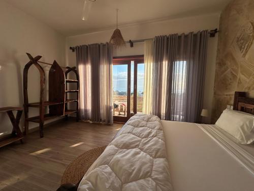 a bedroom with a bed and a large window at Lala salama Kendwa villas in Kendwa