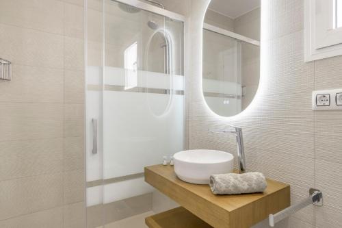 a bathroom with a sink and a mirror at Chalet Fuente2 piscina común famila in Conil de la Frontera