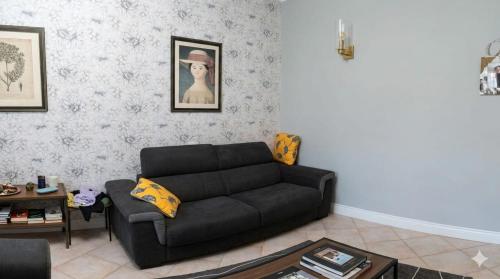 a living room with a black couch and a table at Casa Patrizia in Velletri