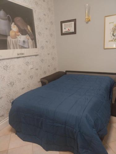a bedroom with a bed with a blue comforter at Casa Patrizia in Velletri